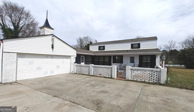 view of front of house with driveway, covered porch, and a garage