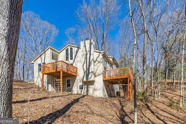 back of property with a chimney and a deck