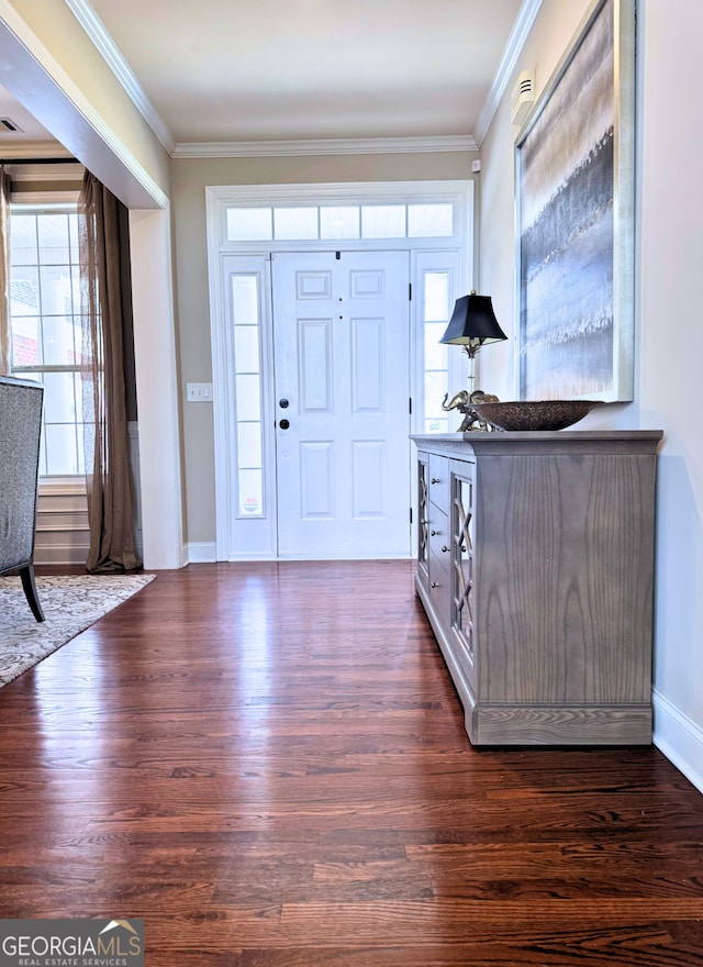 foyer entrance with baseboards, visible vents, ornamental molding, and dark wood-type flooring