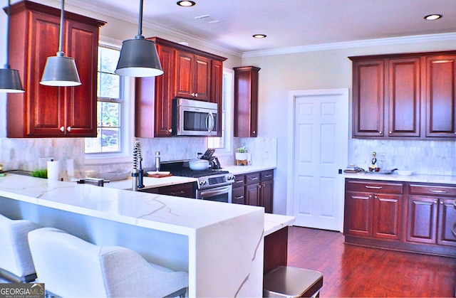 kitchen with stainless steel appliances, a peninsula, dark brown cabinets, dark wood finished floors, and pendant lighting