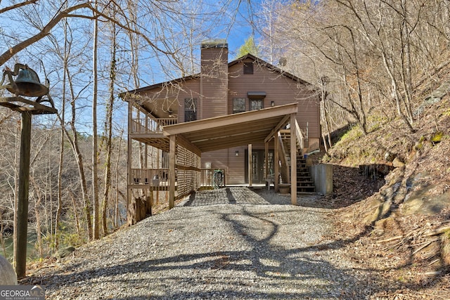 view of property exterior with stairway and a chimney