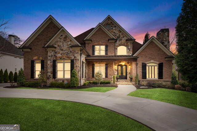 8760 Colonial Pl, Duluth, GA 30097 - french country style house with a chimney, a porch, brick siding, and a front lawn