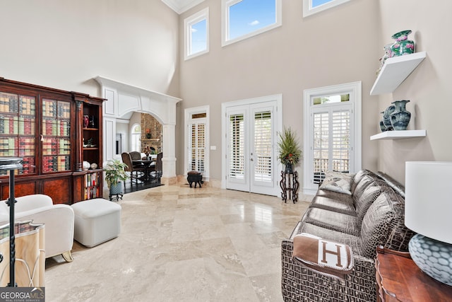 8760 Colonial Pl, Duluth, GA 30097 - living room featuring french doors, marble finish floor, ornamental molding, a towering ceiling, and arched walkways