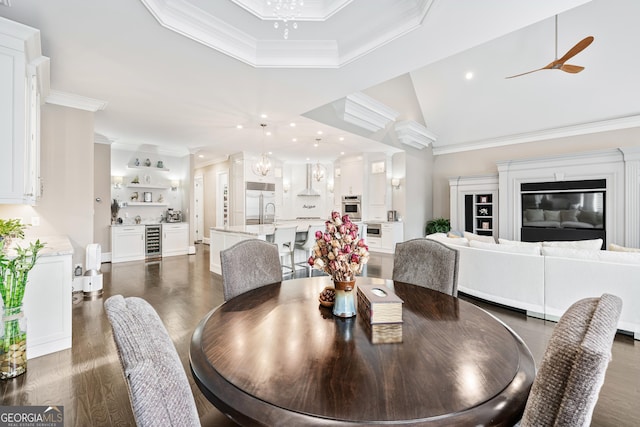 dining area featuring wine cooler, recessed lighting, a high ceiling, dark wood finished floors, and crown molding