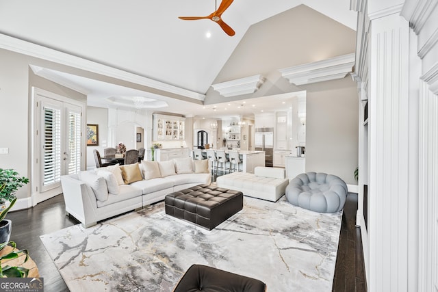 living area featuring baseboards, a ceiling fan, ornamental molding, dark wood-type flooring, and high vaulted ceiling