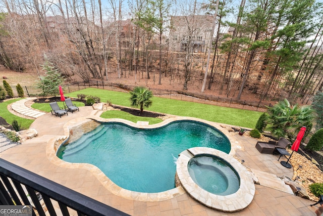 view of pool featuring a yard, a pool with connected hot tub, a fenced backyard, and a patio