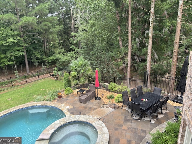 view of swimming pool featuring outdoor dining space, a patio area, a fenced backyard, and a pool with connected hot tub