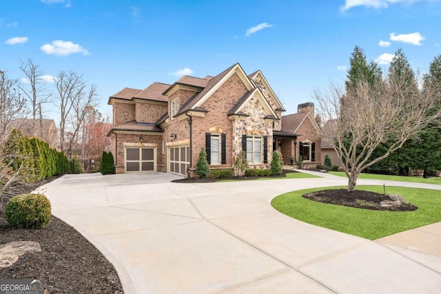 view of front facade with a garage, a front yard, brick siding, and curved driveway