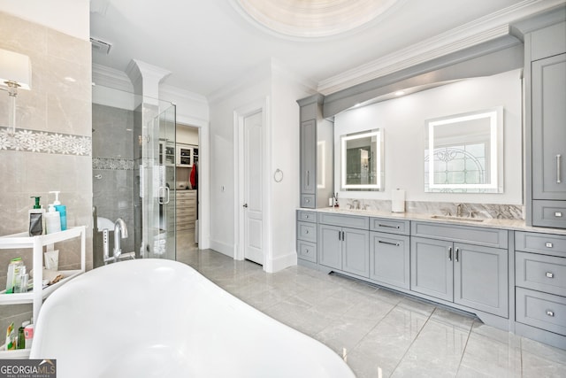 bathroom featuring ornamental molding, a sink, a shower stall, and a freestanding bath