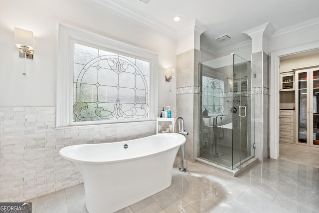 bathroom featuring a stall shower, a freestanding tub, and tile walls