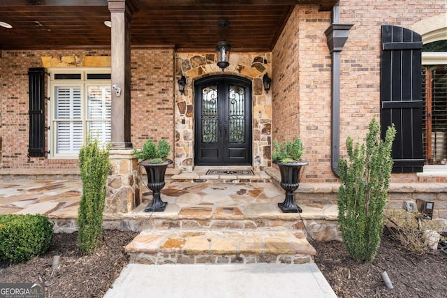 view of exterior entry with french doors and brick siding