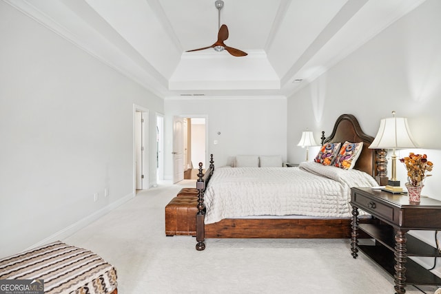 carpeted bedroom featuring a tray ceiling, visible vents, ornamental molding, ceiling fan, and baseboards