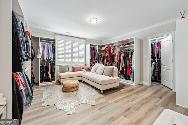 walk in closet with wood finished floors