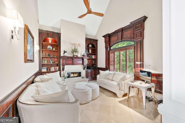 sitting room featuring ceiling fan, high vaulted ceiling, and a glass covered fireplace