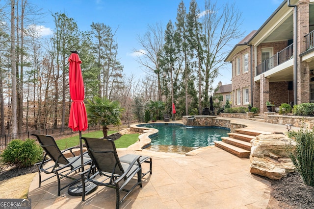 outdoor pool with a patio area and fence