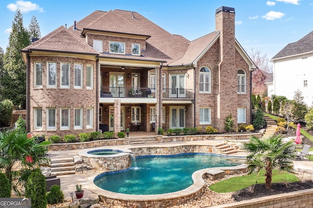 rear view of property featuring a patio, a balcony, a chimney, french doors, and brick siding