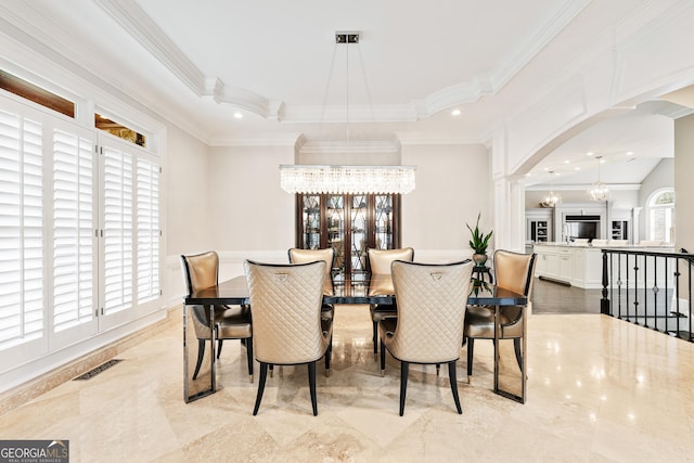 dining space featuring arched walkways, a notable chandelier, a raised ceiling, visible vents, and ornamental molding