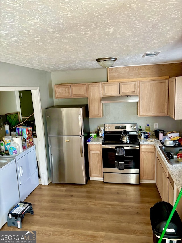 kitchen with visible vents, appliances with stainless steel finishes, washing machine and clothes dryer, light countertops, and light brown cabinets