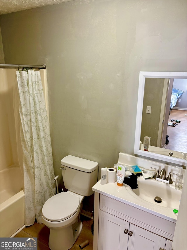 bathroom featuring toilet, shower / bathtub combination with curtain, and vanity