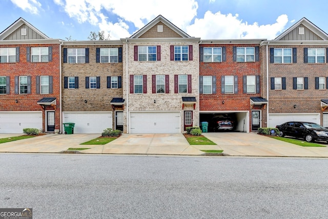 multi unit property featuring brick siding, driveway, and a garage