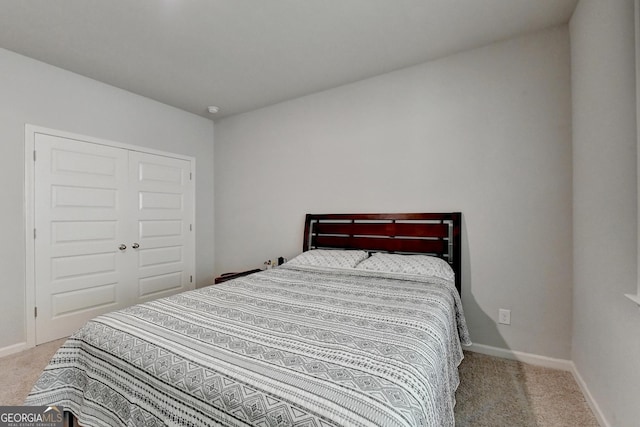 carpeted bedroom with a closet and baseboards