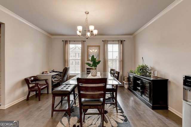 dining space featuring a chandelier, crown molding, baseboards, and wood finished floors