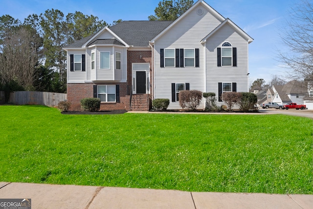 bi-level home with brick siding, fence, and a front lawn