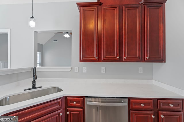 kitchen with reddish brown cabinets, light countertops, a sink, and stainless steel dishwasher