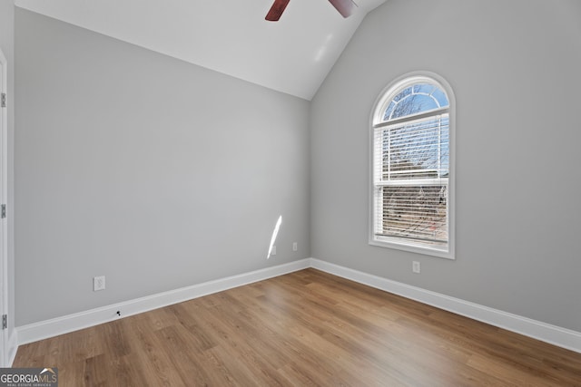 unfurnished room featuring a ceiling fan, baseboards, vaulted ceiling, and wood finished floors