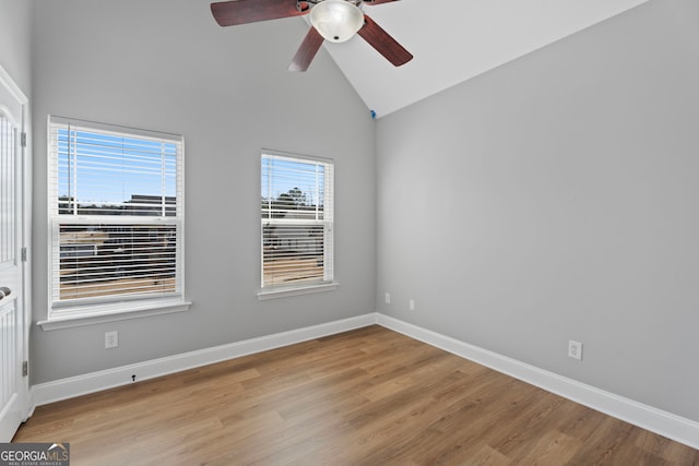 unfurnished room featuring ceiling fan, baseboards, vaulted ceiling, and wood finished floors