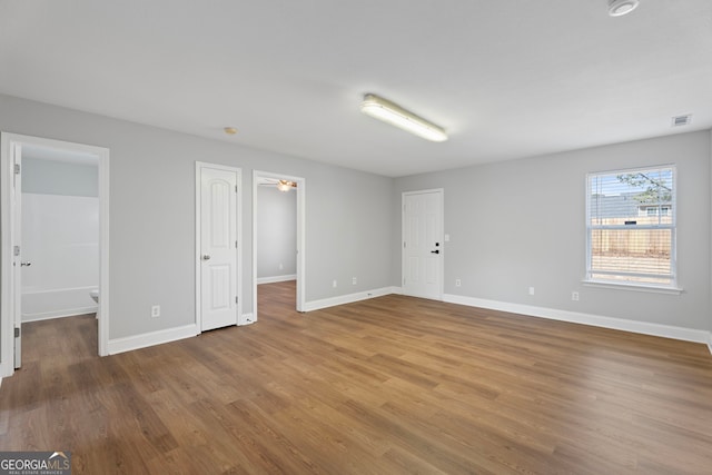 interior space featuring wood finished floors, visible vents, and baseboards