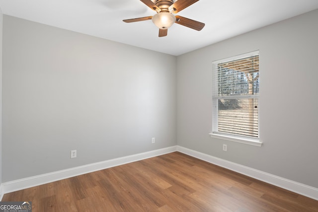 empty room with a ceiling fan, baseboards, and wood finished floors