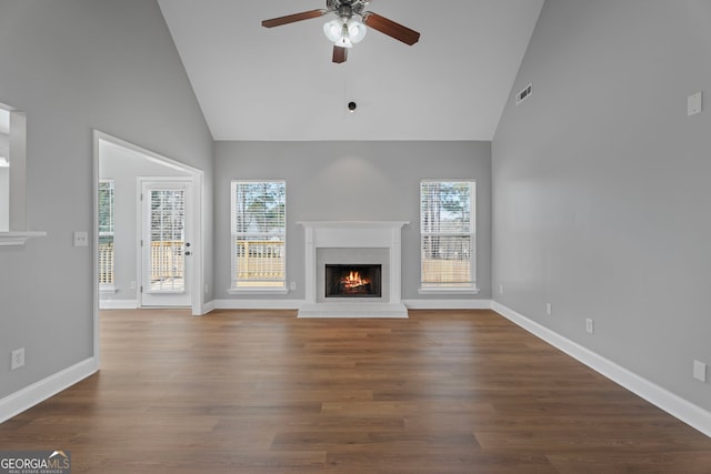 unfurnished living room featuring a brick fireplace, ceiling fan, baseboards, and wood finished floors