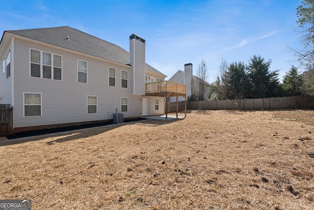 rear view of property featuring cooling unit, fence, a chimney, and a patio