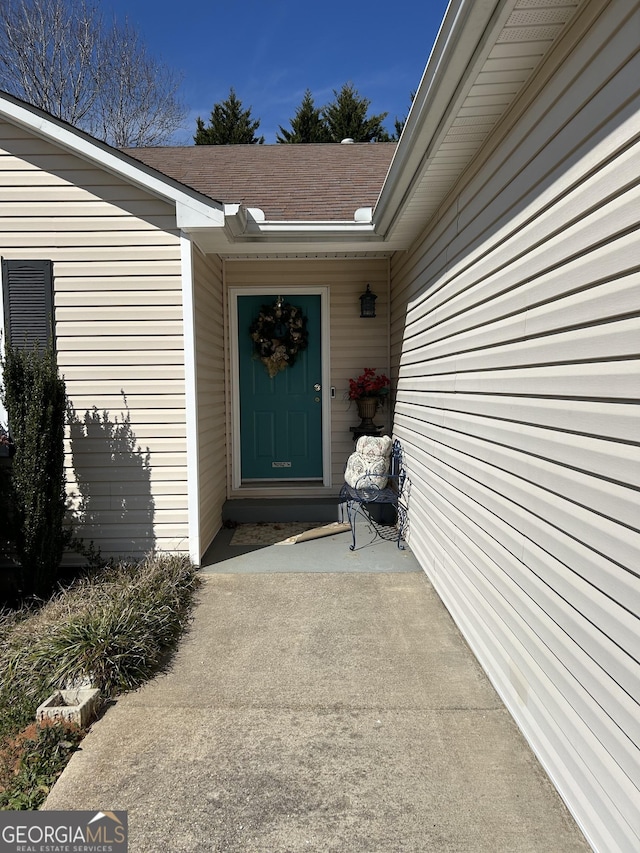 property entrance with a shingled roof