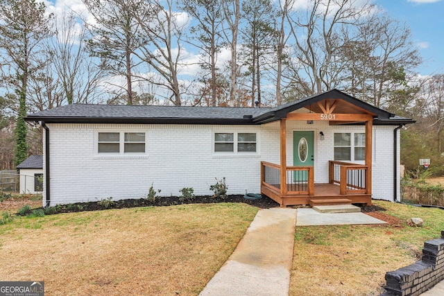 view of front of home with a porch, a front lawn, and brick siding