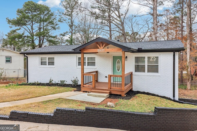 ranch-style house with brick siding, a front lawn, and fence