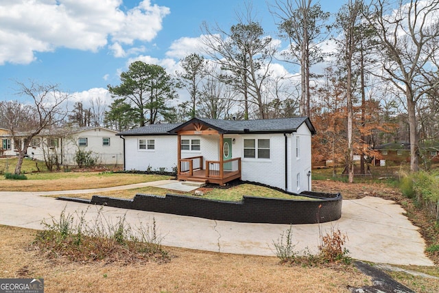 bungalow-style house featuring fence, a front lawn, and brick siding