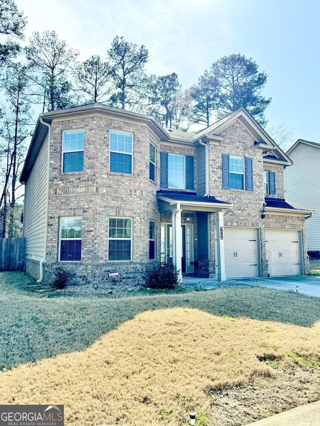 view of front of house featuring a garage, concrete driveway, brick siding, and fence