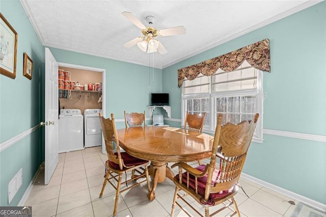 dining room with light tile patterned floors, a ceiling fan, washing machine and dryer, a textured ceiling, and baseboards