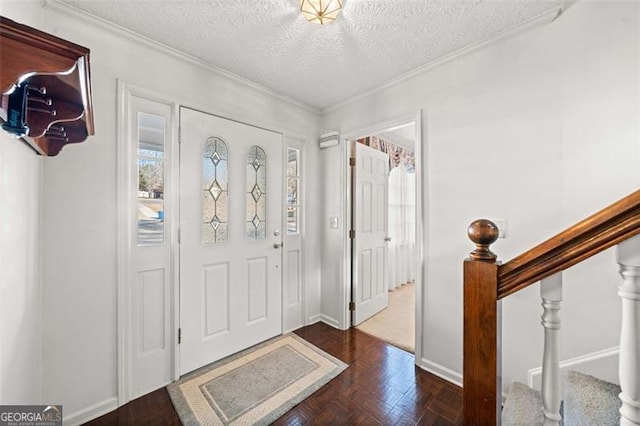 foyer entrance featuring crown molding, a textured ceiling, and baseboards