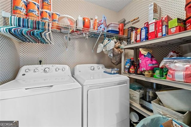 clothes washing area with laundry area, wallpapered walls, a textured ceiling, and separate washer and dryer