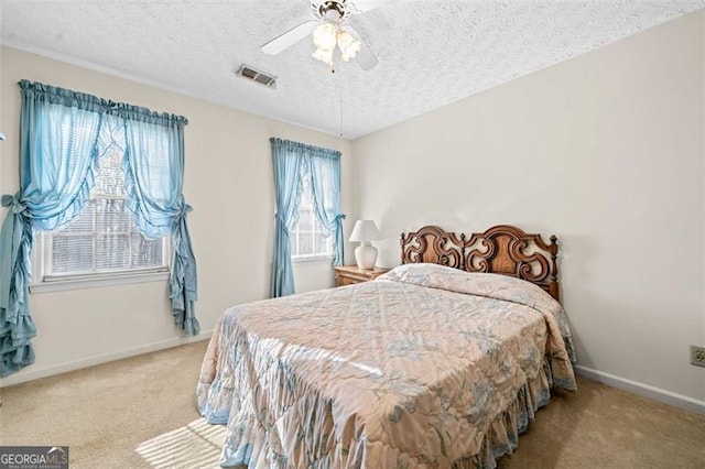 bedroom featuring a textured ceiling, carpet flooring, visible vents, and baseboards