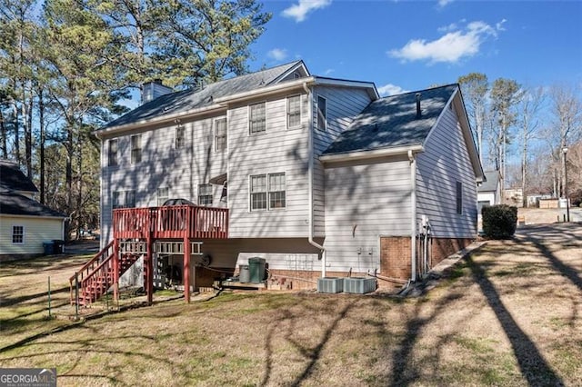 back of property with a deck, central air condition unit, stairway, a lawn, and a chimney