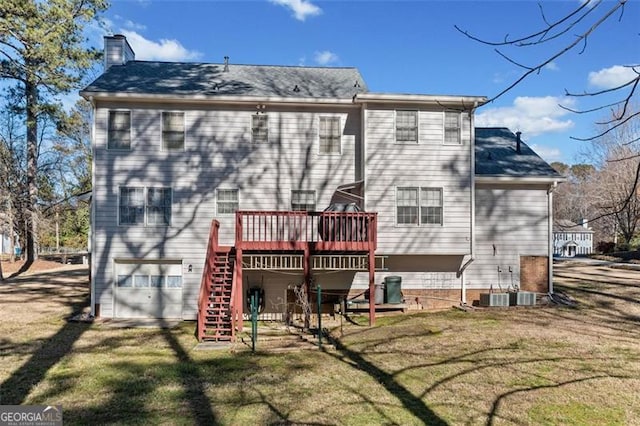 rear view of house featuring a garage, a yard, stairway, and a wooden deck