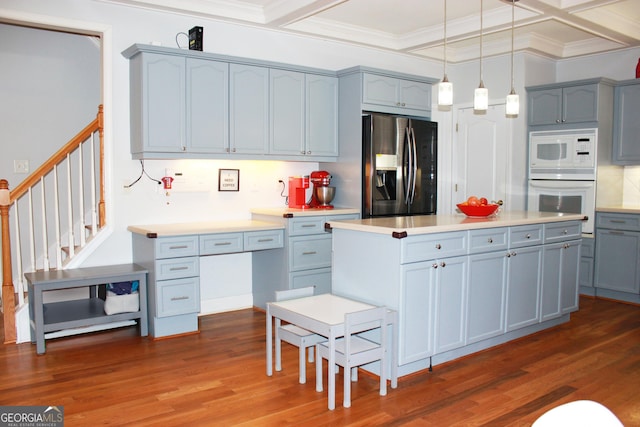 kitchen featuring white appliances, ornamental molding, coffered ceiling, and dark wood-type flooring