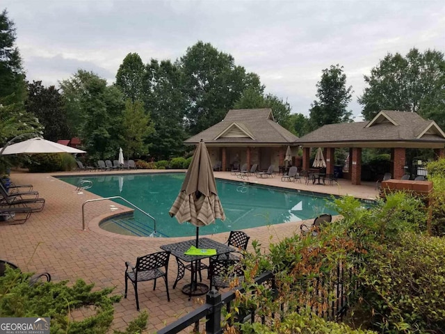 community pool featuring a patio area and fence