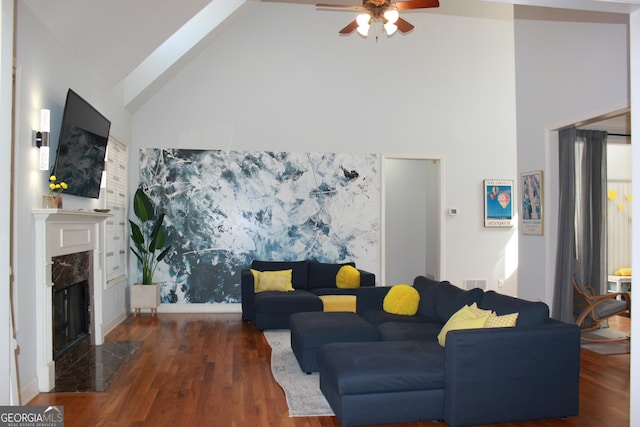 living room with ceiling fan, high vaulted ceiling, a premium fireplace, wood finished floors, and visible vents