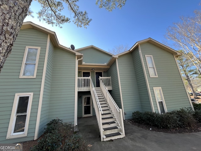 back of property with stairs and a wooden deck