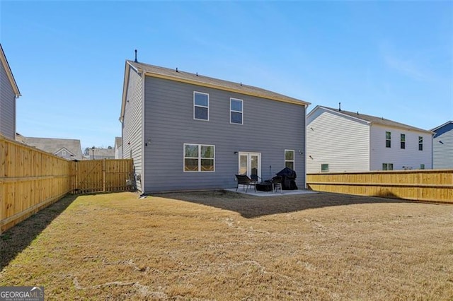 back of house featuring a patio area, a lawn, and a fenced backyard